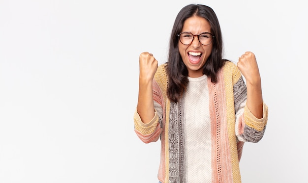 Donna ispanica piuttosto magra che si sente felice, positiva e di successo, celebrando la vittoria