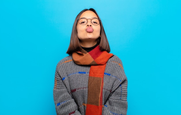 Donna ispanica premendo le labbra insieme a un'espressione carina, divertente, felice, adorabile, inviando un bacio