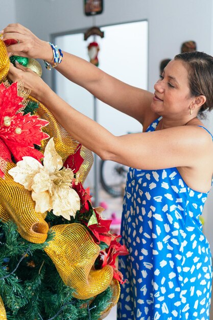 Donna Latina Che Decora L'albero Di Natale A Casa.