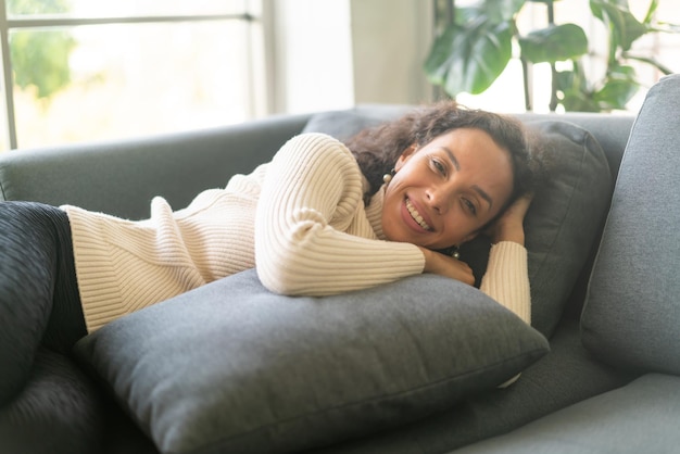 Donna latina che dorme sul divano di casa