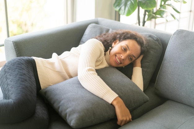 Donna latina che dorme sul divano di casa