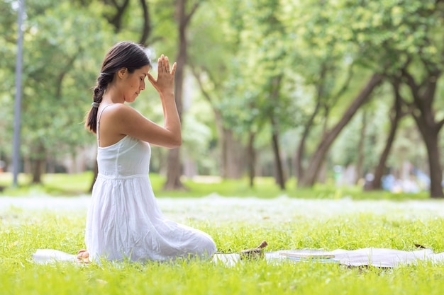 Donna latina che fa meditazione nel parco all'aperto con una ciotola tibetana