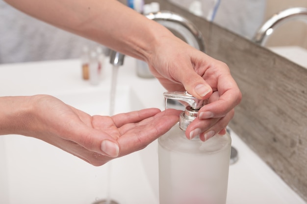 Donna latina che si lava le mani con il sapone a casa