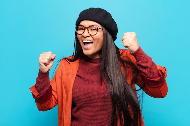 Donna latina che si sente felice, positiva e di successo, celebra la vittoria, i risultati o la buona fortuna