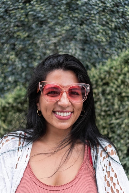 Donna latina con un sorriso e occhiali da sole in città