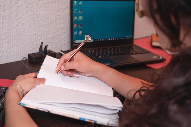 Donna latina di mezza età che scrive nel suo spazio di lavoro