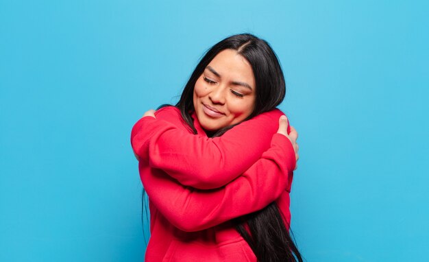 Donna latina innamorata, sorridente, coccolata e abbracciata, single, egoista ed egocentrica