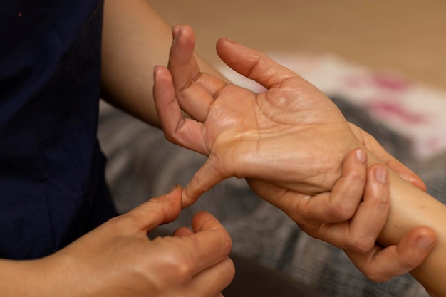 Donna latina sdraiata sulla schiena che riceve un massaggio ayurvedico tra le mani