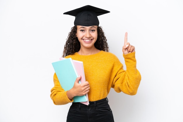 Donna laureata all'università araba che tiene libri isolati su sfondo bianco che punta verso l'alto una grande idea