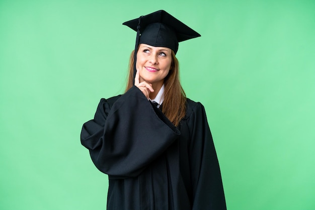 Donna laureata universitaria di mezza età su sfondo isolato che pensa un'idea mentre guarda in alto