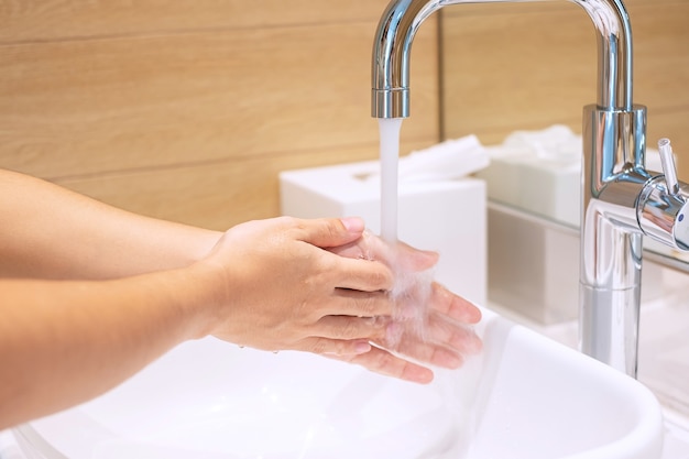 Donna lavarsi le mani con sapone liquido