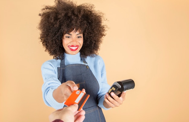 Donna lavoratrice latina abbastanza ispanica che carica con la carta, fondo beige