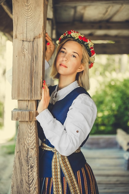 Donna lettone in abiti tradizionali in posa sulla natura nel villaggio