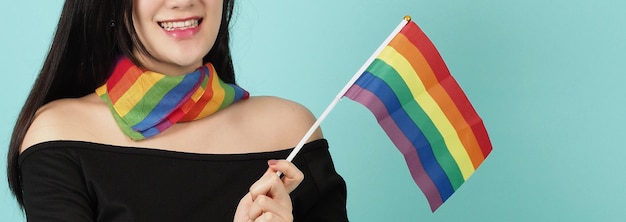 Donna LGBTQ con bandiera dell'orgoglio in piedi su uno sfondo verde blu