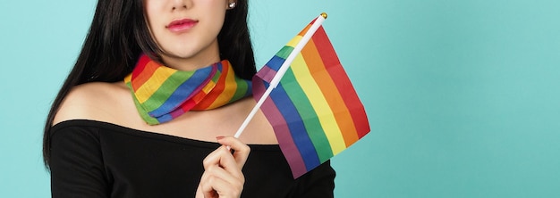 Donna LGBTQ con bandiera dell'orgoglio in piedi su uno sfondo verde blu