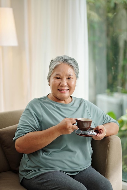 Donna maggiore che gode della tazza di caffè