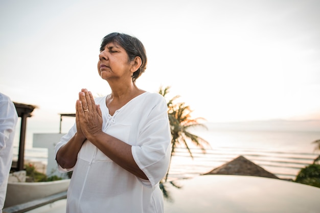 Donna maggiore che pratica yoga al mattino