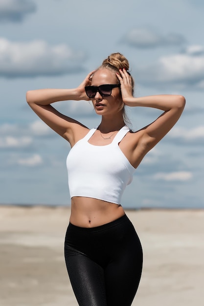 Donna magra che si allunga alzando le mani sulla spiaggia