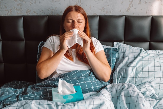 Donna malata con infezione da raffreddore da naso che cola da fazzoletto