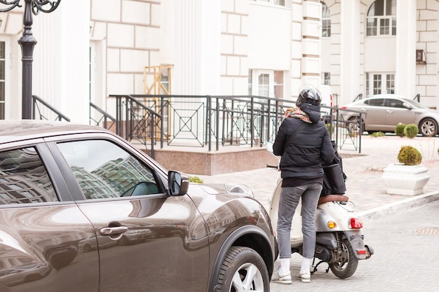 donna mascherata che consegna cibo su una moto