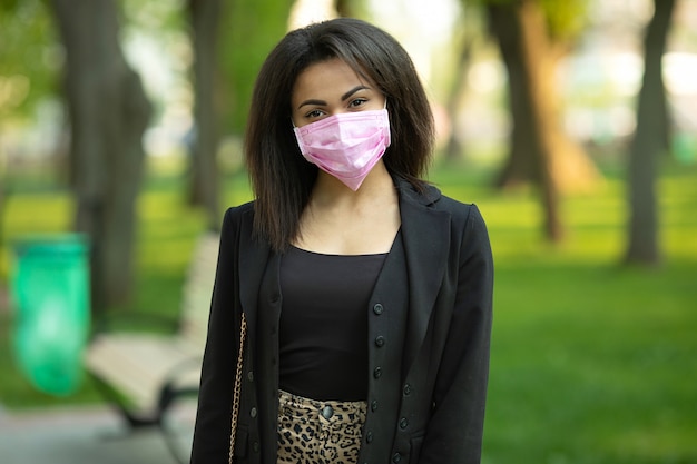 Donna mascherata - protezione contro il virus dell'influenza. African - American woman indossa maschera per proteggere.