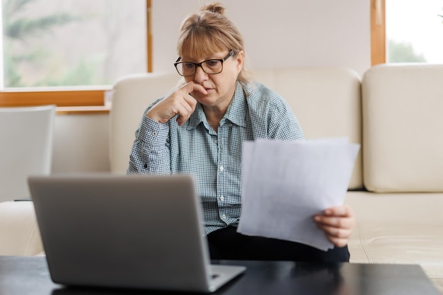 Donna matura attiva che utilizza un computer portatile per lavorare a distanza dall'ufficio domestico Videoconferenza videoconferenza L'insegnante senior conduce il webinar