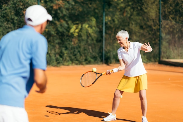 Donna matura che gioca a tennis