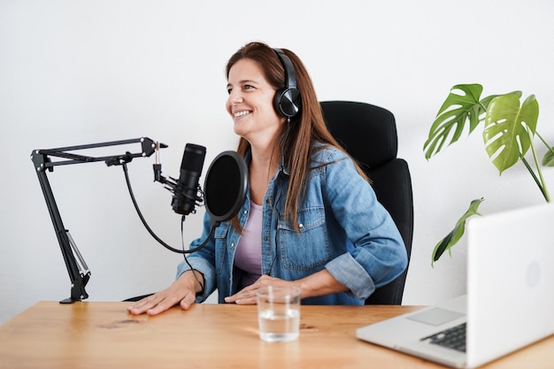 Donna matura che registra un podcast all'interno dello studio