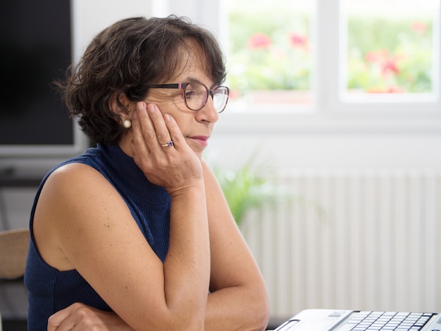 Donna matura con il suo laptop in casa