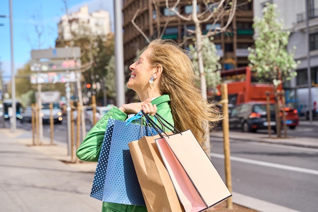 donna matura con le borse della spesa sulla spalla