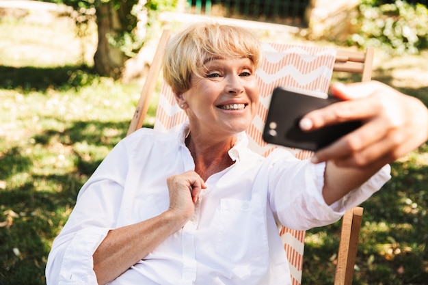 Donna matura felice che prende un selfie