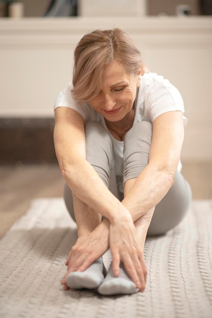 Donna matura in buona salute che si rilassa dopo gli esercizi di yoga