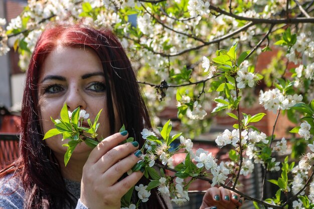 Donna matura in piedi vicino ai fiori di ciliegio