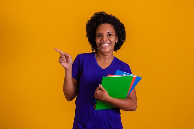 Donna matura studente sorridente guardando la fotocamera con spazio per il testo su sfondo giallo Donna matura studente nero