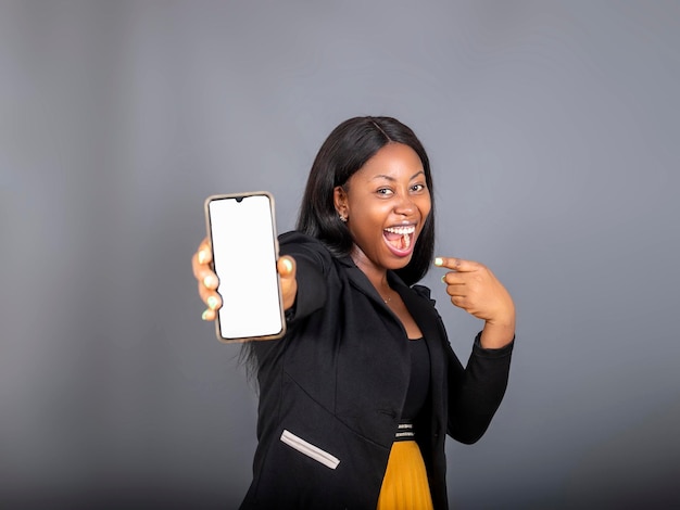 Donna millenaria felicissima in piedi Donna eccitata isolata che punta il dito contro lo smartphone