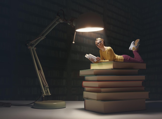Donna minuscola che legge libri in una biblioteca buia