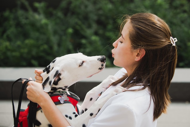 Donna moda stile bella ragazza che cammina con il cane per strada cane leccare e baciare la ragazza