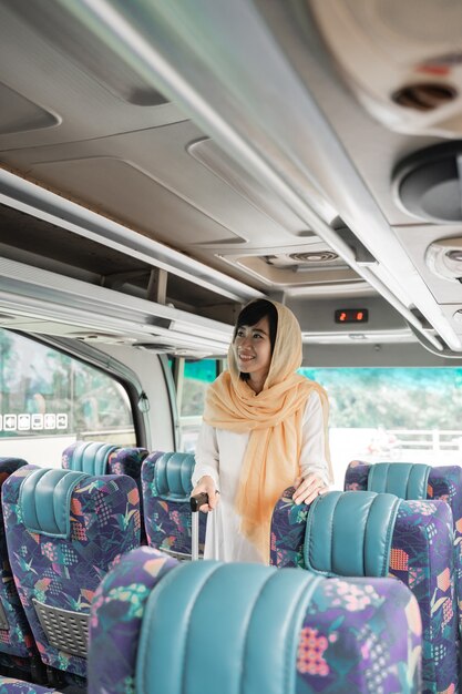 Donna musulmana asiatica che fa viaggio di ritorno alla sua città natale in sella a un autobus