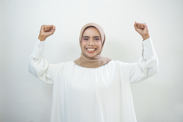 Donna musulmana asiatica emozionante che celebra la vittoria isolata sopra priorità bassa bianca