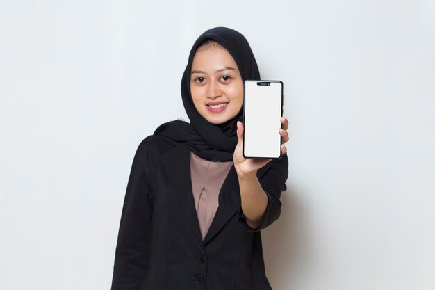 donna musulmana asiatica in hijab che dimostra il telefono cellulare