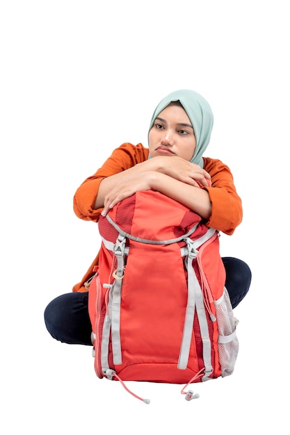 Donna musulmana asiatica in un velo seduto con uno zaino
