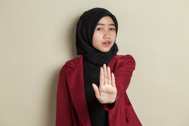 Donna musulmana asiatica sconvolta seria che mostra gesto di mano di arresto