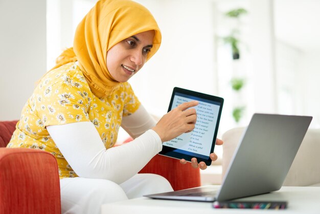 Donna musulmana che insegna su tablet a casa oggi