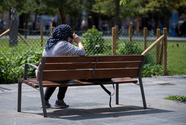 Donna musulmana che parla al cellulare mentre riposa