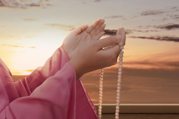 Donna musulmana che prega con i grani di preghiera nelle sue mani