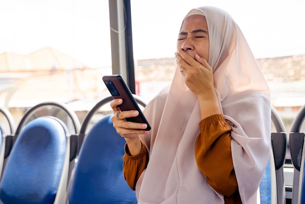 Donna musulmana che sbadiglia mentre guida un autobus pubblico