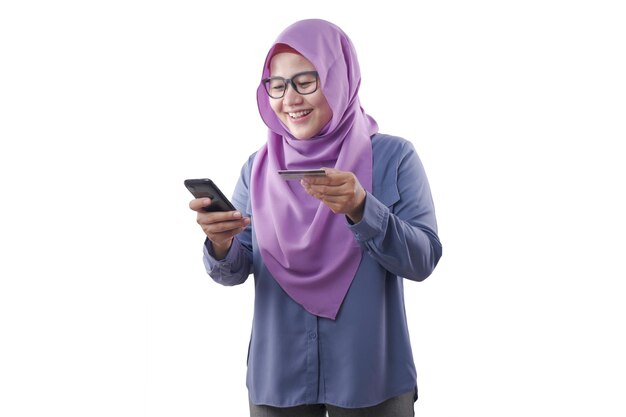 Donna musulmana che sorride e fa acquisti online dal suo telefono cellulare