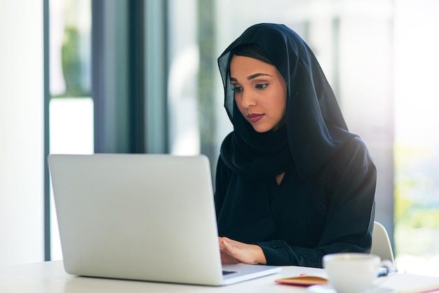 Donna musulmana e laptop per carriera lavora in ufficio su internet per dubai e tecnologia Computer professionale e arabo con hijab è sul web per progettare in un'azienda con tecnologia