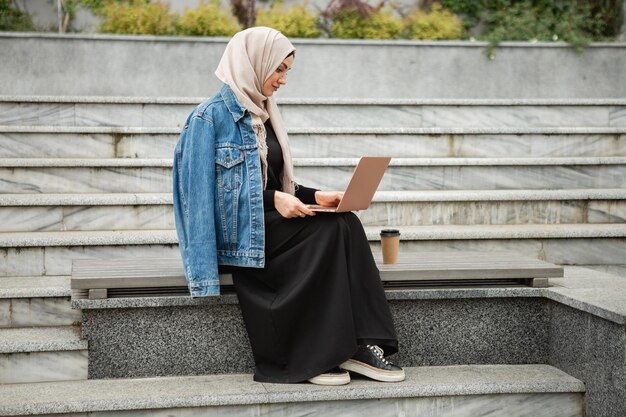 Donna musulmana moderna ed elegante in hijab in una strada di città