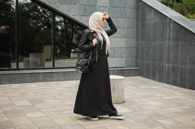 Donna musulmana moderna ed elegante in hijab in una strada di città